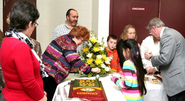 Children and adults line-up to receive a slice of Conway’s centennial cake following Wednesday’s celebration at the Middle School. Staff Photo by Amanda VanDerBroek