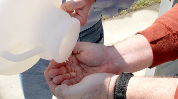 Treated wastewater is clean and clear as shown here being poured from a sample container into the hands of Ahoskie WWTP Superintendent Stewart White. Staff Photo by Cal Bryant