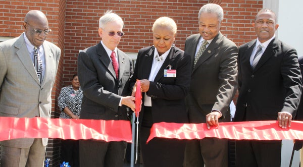 Retired Northampton DSS Director Dr. Al Wentzy (second from left) joins with current Director Shelia Manley-Evans to cut the ribbon that formally opened the county’s new Department of Social Services building on Wednesday. Others joining the grand opening ceremony were, from left, Northampton Commissioners Chairman Robert Carter, DSS Board Chairman Eugene Taylor, and Randy Gore, State Director of USDA Rural Development. Staff Photo by Cal Bryant 