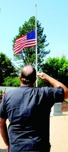 A military veteran salutes the flag flying at half-staff at Conway’s Veterans Park on Monday as he and others paused to pay their respect on Memorial Day. Staff Photo by Cal Bryant