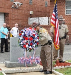 A member of the Northampton County Sheriff’s Honor Guard lays a wreath at a granite marker erected in memory of three Northampton County officers killed in the line of duty since 1980. Staff Photo by Cal Bryant