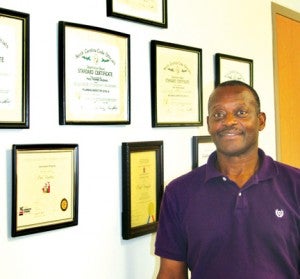 Town of Ahoskie Code Enforcement Officer Paul Vaughan poses in his office at the Ahoskie Fire Station where a wall displays his numerous state licenses and certifications. Staff Photo by Gene Motley