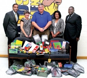 W.I.N. members Aaron Jordan (left) and James Futrell (right) donated back-to-school supplies to HCPS principals (center, from left) Julie Shields, Stan Warren and Lori Morings on Friday morning. Staff Photo by Cal Bryant
