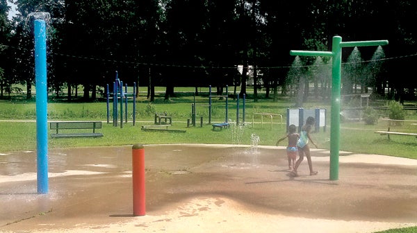 Tariq Rahim and Tamara Rahim run through the sprinklers at the Woodland Playground Park as they cool off on a hot summer day. Photo by Lloyd Vinson