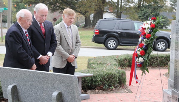 From left, Murfreesboro military veterans Joe Dickerson, David Farnham and Doug Deets pause in silence after laying a wreath on Tuesday at the War Veterans Memorial. Staff Photo by Cal Bryant