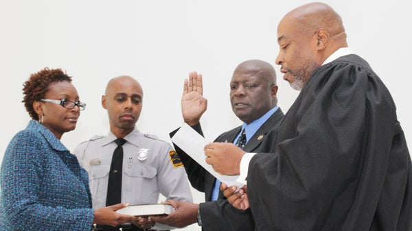 Northampton County Sheriff Jack Smith (second from right) accepts the oath of office from Chief District Court Judge W. Rob Lewis (right). Taking part in the ceremony are the Sheriff’s children, from left: Jacqueline Barnes and William Smith. Staff Photo by Cal Bryant