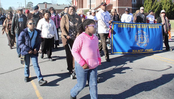 Those taking part in Monday afternoon’s “Community Unity” march make their way east on Main Street en route to a service at New Ahoskie Baptist Church. Staff Photo by Cal Bryant