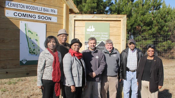 From left, Charlanda Shepard of the Mid-East Commission, Leonard Mobley, outgoing State Representative Annie Mobley, NC Wildlife Commission officials Erik Christofferson and Christian T. Waters and Bertie residents George and Marion Lee pose for a photo at the entrance to a new boating access area, located off Weeping Mary Road near Woodville. Staff Photo by Cal Bryant