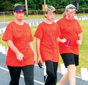 Cathy Pierce (left) and her son Christopher, along with Elizabeth Eure, walk 75 of the 100 laps they pledged for their Friends of Relay (F-O-R) team. It was the most laps by an individual.  In all, F-O-R completed the most team laps: 267. Staff Photo by Gene Motley