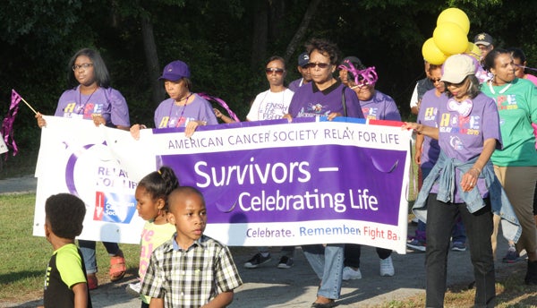 Cancer survivors were honored with the task of carrying the Relay for Life banner on the first lap of Friday’s opening ceremonies at the Cultural & Wellness Center in Jackson. Staff Photo by Cal Bryant
