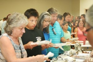 The Native American visitors sample Bertie County cuisine at the Indian Woods church luncheon honoring Tuscarora tribe members who came from NY state for the weekend to visit their ancestral home. Staff Photo by Gene Motley