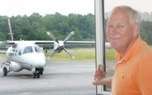 Longtime Tri-County Airport Manager Henry Joyner is shown at the airport terminal.  In the background is a Mitsubishi MU-2 Peacock turboprop that had flown in passengers to this area for conducting local business. Staff Photo by Gene Motley