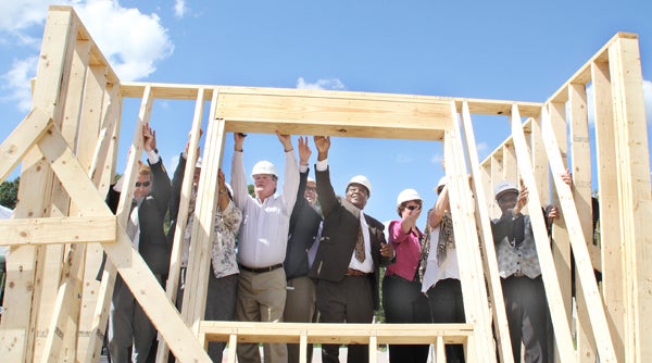 Officials with The Affordable Housing Group of North Carolina are joined by representatives of several funding agencies and Town of Ahoskie Council members as they raise the ceremonial first wall at Cypress Court Apartments, a 48-unit complex now under construction behind Newmarket Shopping Center. Staff Photo by Cal Bryant