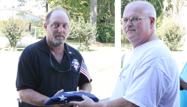 Conway VFD Chief Albert Vann (left) accepts the new American Flag that now flies above the station from WoodmenLife Chapter 862 member Edward Nelson. Staff Photo by Cal Bryant