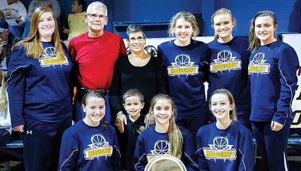Members of the Ridgecoft School varsity girls basketball team pose with Keith and Joyce Brantley, parents of the late US Navy Lt. Nick Brantley, after winning the tournament championship for the second straight year. Team members are, kneeling from left, Emily Grace, Emma Wood Boone, and Sydney Lane; and, standing from left, MacKenzie Brown, Cameron Basnight, Ruthie Daniels and Reagan King. | 2nd Chance Productions / Andre Alfred