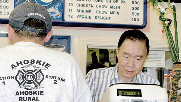 Raymond Ng (right) is shown here ringing up a customer’s order behind the counter of his popular Chinese restaurant located in the Ahoskie Commons Shopping Center. | Staff Photos by Keith Hoggard
