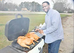 Ishmael Muldrow, organizer of the coat drive, prepares his turkey barbecue which he served to those who participated in the collections.