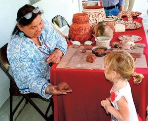 Senora Lynch, a member of the Haliwa Saponi tribe, shows off a pottery turtle she has made to CarolJean Pierce of Jamesville during the Lost Colony Festival Saturday in Windsor. See page 3 of today’s edition for additional photos, as well as on the News-Herald’s Facebook page. | Staff Photo by Gene Motley