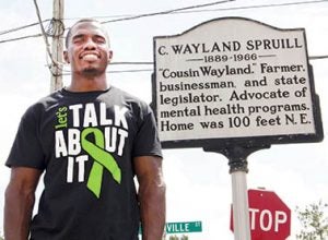 Casey Owens, one of the event organizers, stands adjacent to a State Historical Marker that pays honor to a Bertie County native and former North Carolina legislator that took up the cause for mental health statewide. 