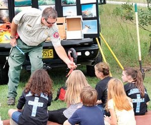 Assistant Hertford County Forest Ranger Jason Odom gives Ahoskie Christian School fifth graders a closer look at a sample taken from a pine tree that revealed its age.