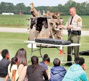 With a display of creatures found in the wild here in the R-C area shown in the background, NC Wildlife Commission Officer Tim Wadsworth leads an informative session with a group of Ahoskie Elementary School fifth graders.