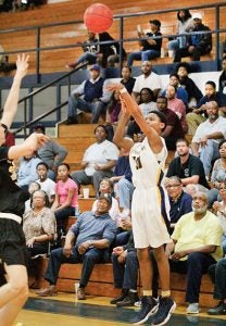 The crowd looks on as Hertford County’s Talik Totten launches a three-point shot during Saturday night’s home game vs. Roanoke Rapids. Totten swished the nets on five, long-range bombs, part of his game-high 28 points, that aided the Bears in their 71-56 victory. | Staff Photo by Cal Bryant